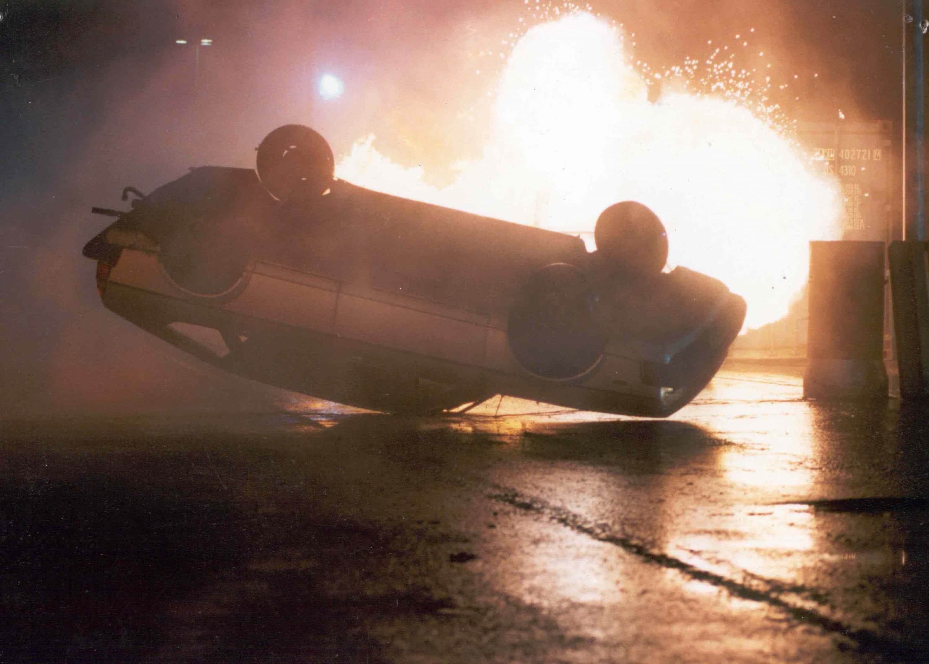 Autostunts met een explosie op de achtergrond.